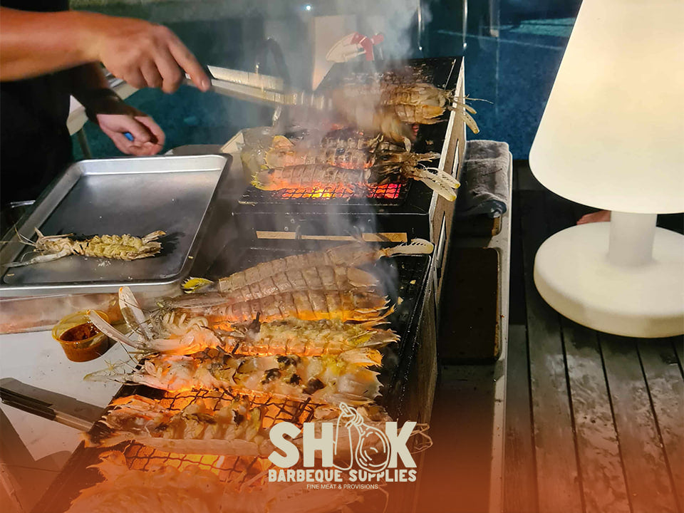 新加坡派对上,Shiok BBQ 助手在甲板上烤虾和肉
