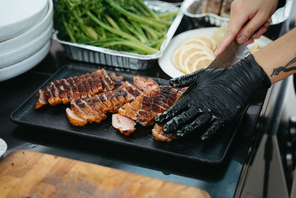 Shiok BBQ 厨师在新加坡现场烧烤站为宾客摆盘烤牛排