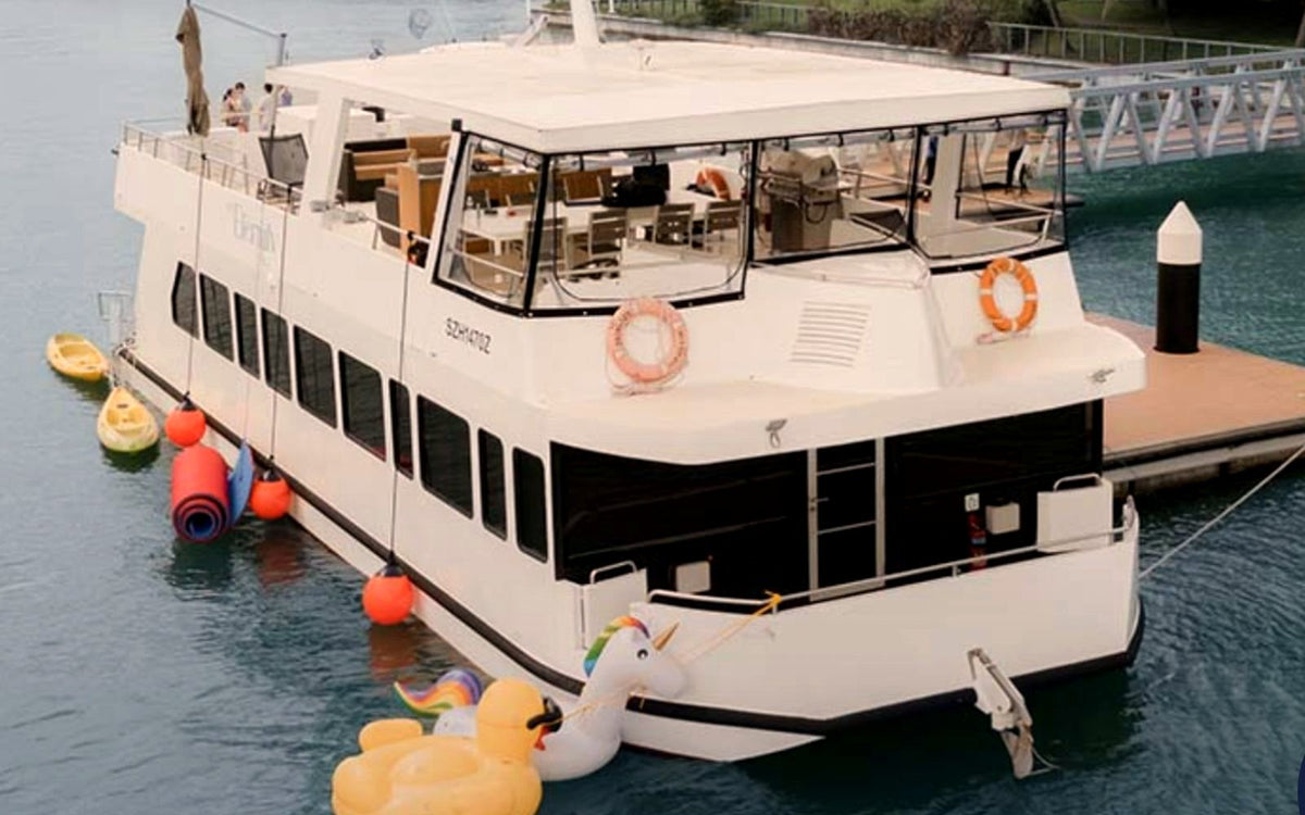 Yacht Maison charter at the marina, upper deck set with dining tables and a grill
