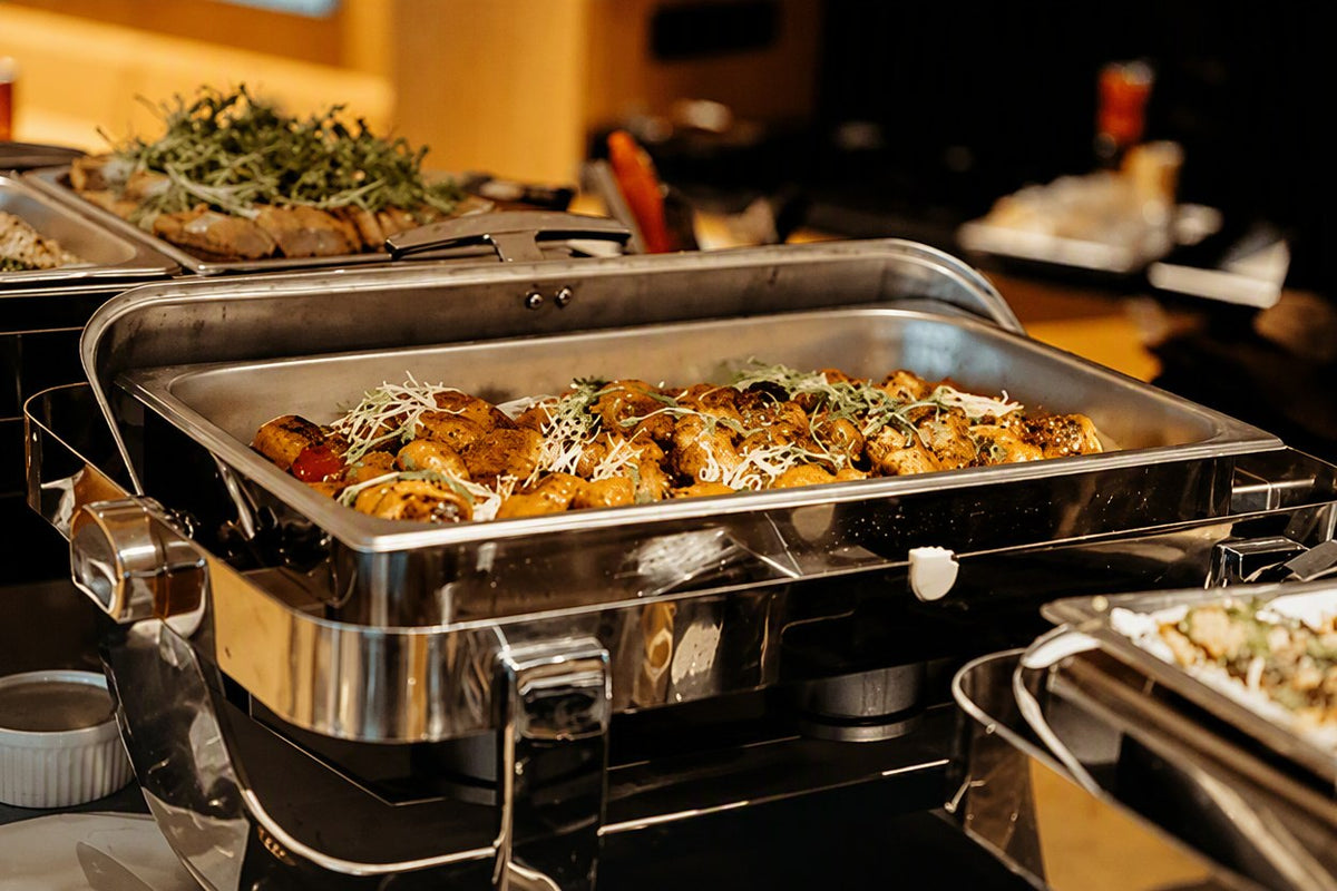 Herb roasted potatoes in a stainless chafing dish at a Western buffet catering setup by Shiok BBQ Singapore