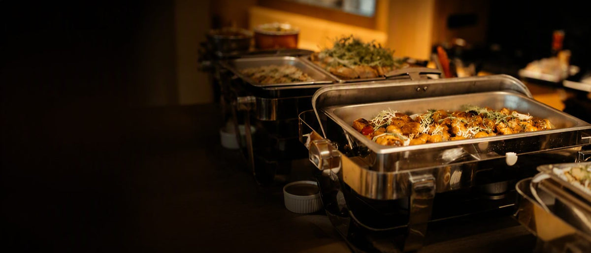 Chafing trays of freshly cooked buffet dishes at a Shiok BBQ onsite buffet catering setup in Singapore