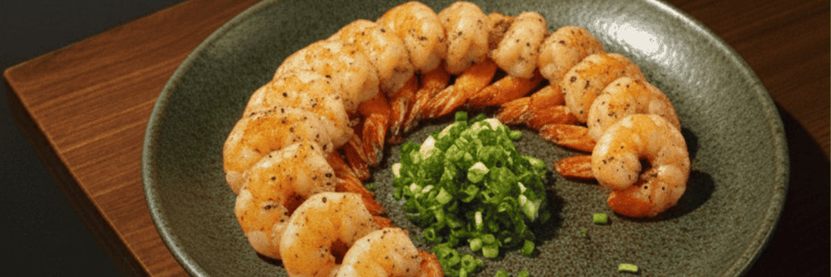 Seasoned prawns arranged with spring onion on a plate from Shiok BBQ in Singapore