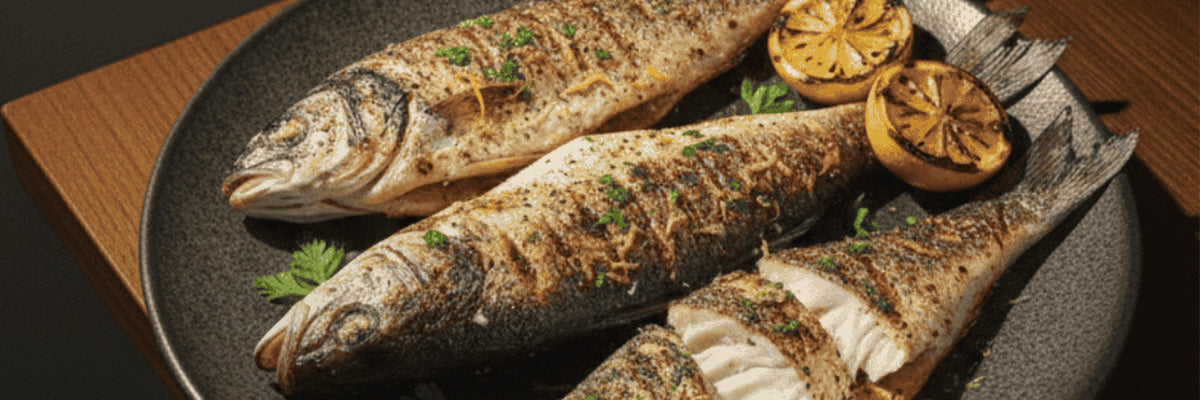 Whole grilled fish with charred lemon on a plate from Shiok BBQ in Singapore