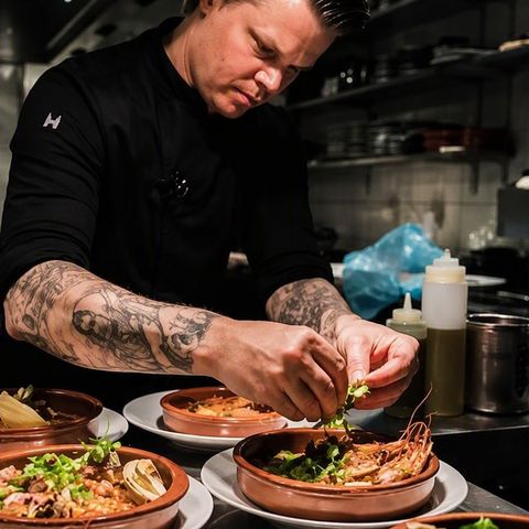 Shiok BBQ team member plating and garnishing dishes ready to serve